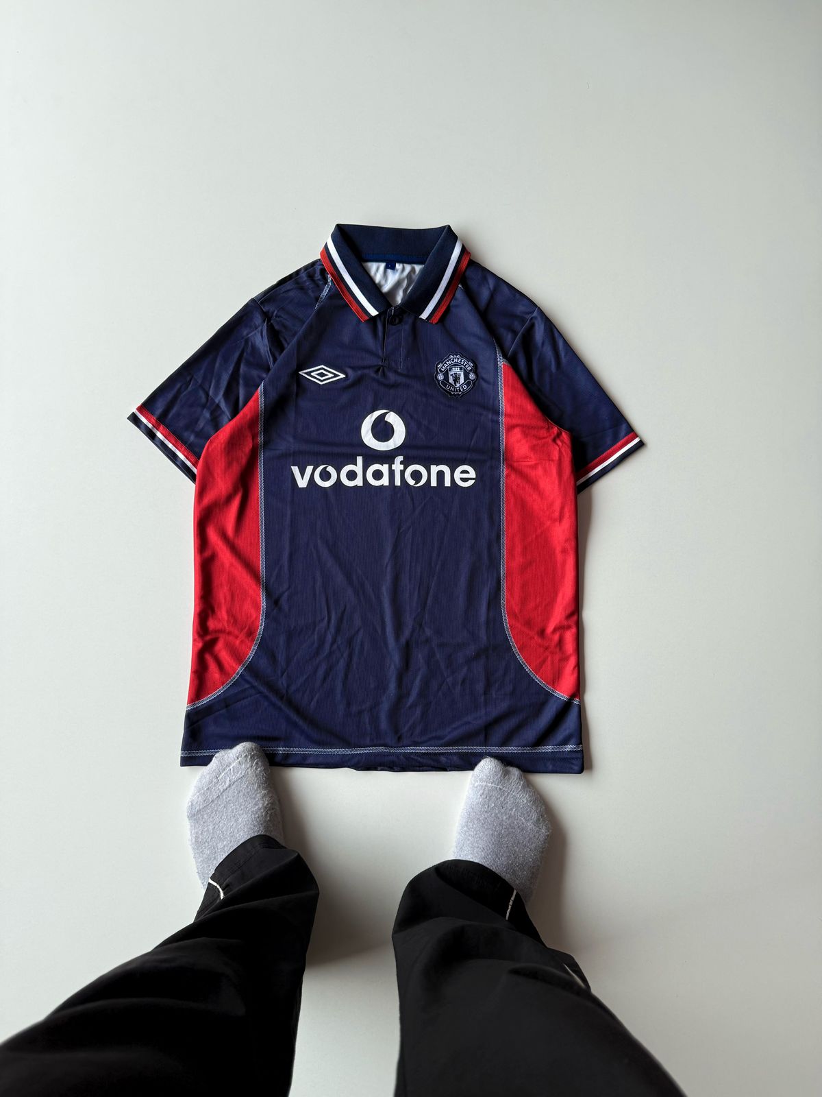 Front view flat lay of the retro Manchester United 2002 2003 third jersey in deep navy blue featuring vibrant red mesh side panels at vamstore India.