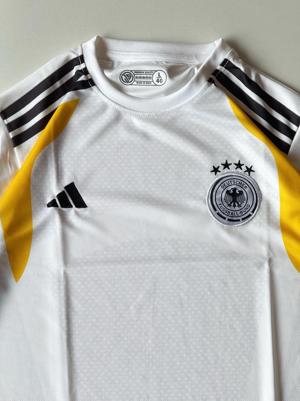 Close-up front view of the Germany 2024 home jersey showcasing the premium embroidered DFB team crest with four stars and black shoulder stripes at vamstore India.